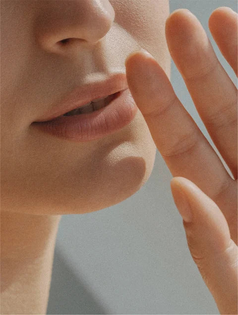 Vrouw met gevoelige huid en natuurlijke uitstraling, toont een frisse en gezonde gloed. De sfeer is zacht en rustgevend.